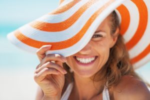 woman in sun hat with dental implants in Gahanna smiles