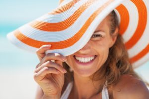 woman in sun hat with dental implants in Gahanna smiles 